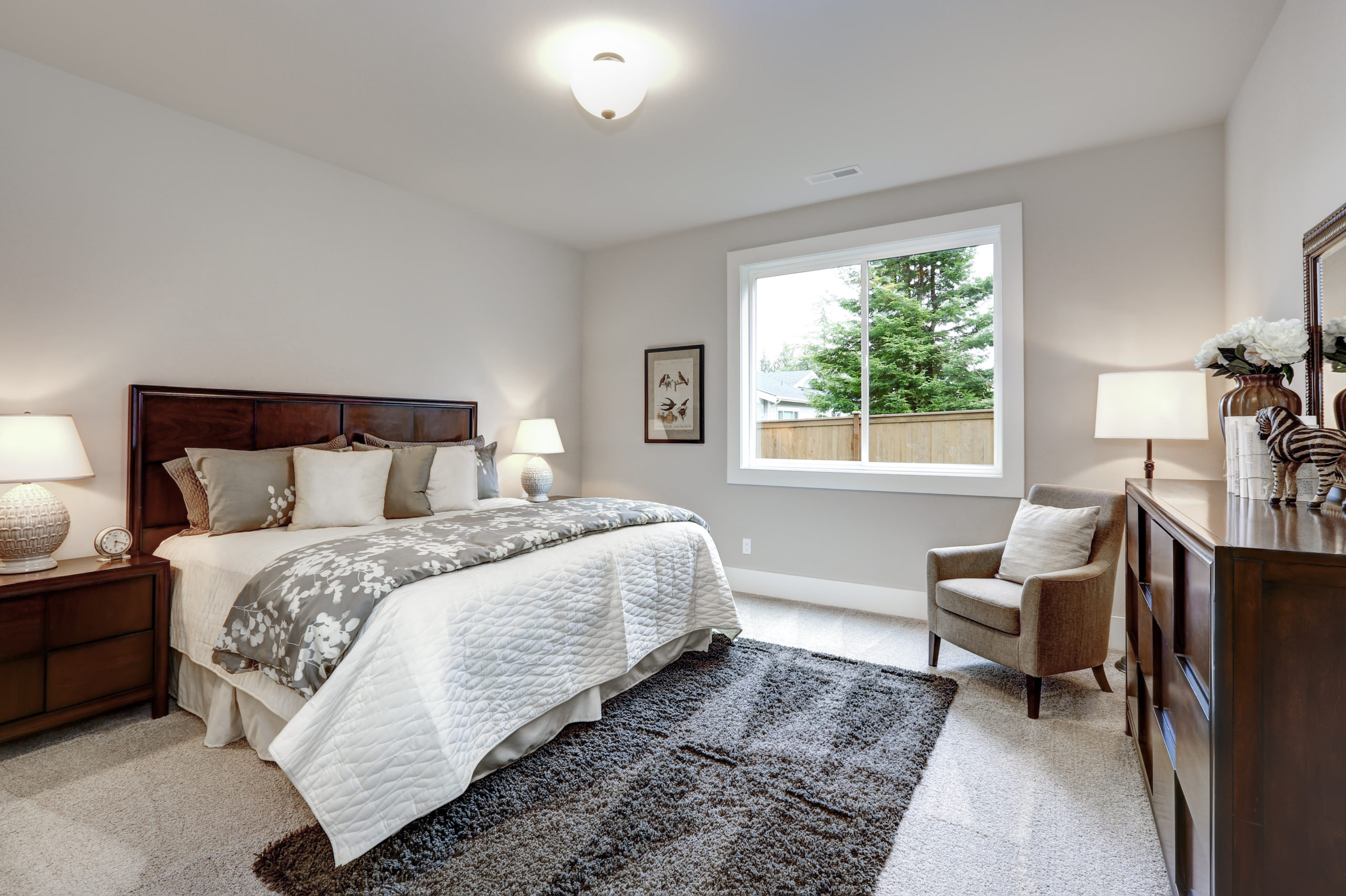 Light modern master bedroom interior with darkwood bed and dresser springfield il